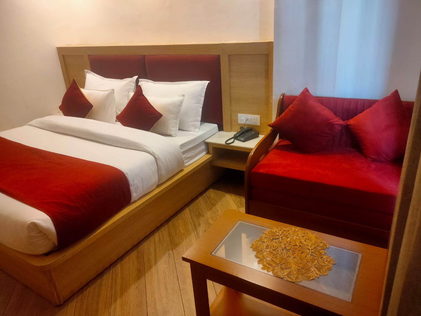 Deluxe room with king bed and red sofa seating